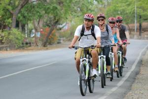 a group of people riding bikes down a road at Adi Assri Beach Resorts And Spa Pemuteran in Pemuteran +45 photos
