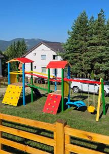 a playground with colorful play equipment in a yard at Vila Dzavric in Zlatibor