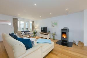 a living room with a couch and a fireplace at 64 Una in Carbis Bay