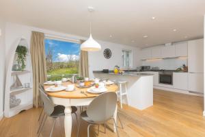 a kitchen and dining room with a table and chairs at 64 Una in Carbis Bay