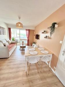 a living room with a table and a couch at Le Cocon, 100m de la plage, place de parking privé in Saint-Hilaire-de-Riez