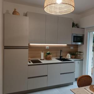 a kitchen with white cabinets and a refrigerator at Onda d'Oro in Finale Ligure