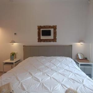 a bedroom with a white bed with a picture on the wall at Onda d'Oro in Finale Ligure