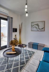 a living room with two tables and a couch at Beachfront Blue Comfort Sitia By ComfortBnb in Sitia