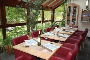 a restaurant with wooden tables and red chairs at Camping Kautenbach in Kautenbach