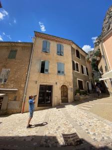 a man taking a picture of a building at La Bonne Etoile - The Good Star in Moustiers-Sainte-Marie