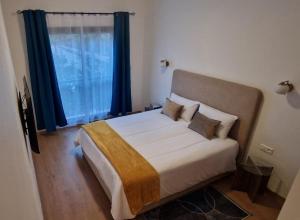 une chambre avec un grand lit avec des rideaux bleus dans l'établissement Appartement Domaine de Noria, à Marrakech 21 autres photos