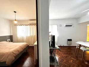 a bedroom with a bed and a desk with a television at Excelente ubicación en el Bv. más lindo de Rosario in Rosario