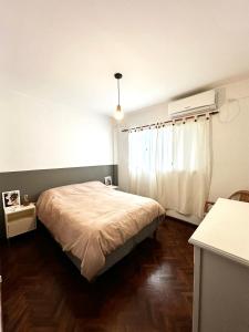 a bedroom with a bed and a window with a heater at Excelente ubicación en el Bv. más lindo de Rosario in Rosario