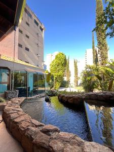 a pond in front of a building at Hotel Nações Plaza in Bauru