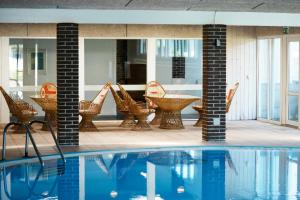 布赖斯楚普佩吉瑟加登酒店的游泳池，露台上摆放着藤椅和桌子