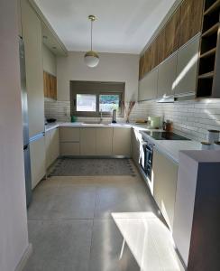 a large kitchen with white appliances and a window at The little house in Kaiafas in Sidhirodhromikós Stathmós Zakháros