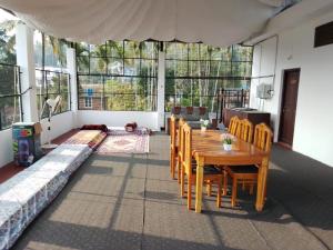 a living room with a wooden table and chairs at Brighton Stays in Sultan Bathery