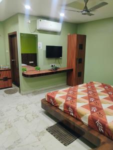 una camera con letto e TV a parete di Umas Regency a Guwahati