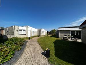 ユリアーナドルプにあるBungalow Noordzee Dの煉瓦造りの家の前の通路