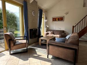a living room with a couch and chairs and a table at Albatros 327 in Julianadorp