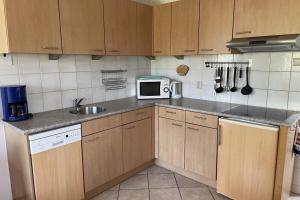 a kitchen with a sink and a microwave at Albatros 327 in Julianadorp +6 photos