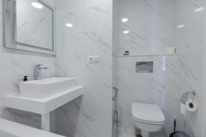 a white bathroom with a sink and a toilet at Batum World 2014 in Batumi +14 photos