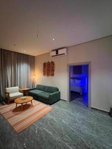 a living room with a green couch and a table at 430 Guest House Residential Hotel in Islamabad