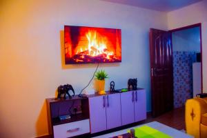 a living room with a fire on the wall at Micasa Homes BnB D1 in Limuru