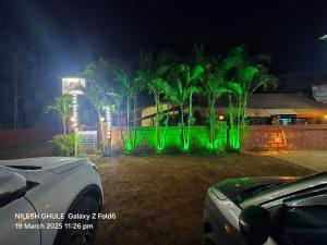 a group of palm trees with green lights at A Ghule Patil Family Beach in Diveagar