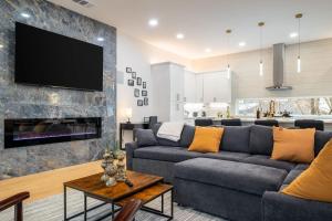 Una sala de estar con un sofá y un televisor en una pared. en Luxury 4BR Townhouse with Rooftop Patio and BBQ, en Dallas
