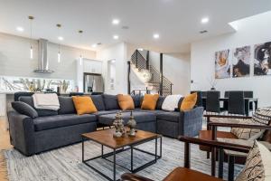 Una sala de estar con un sofá azul y una mesa. en Luxury 4BR Townhouse with Rooftop Patio and BBQ, en Dallas 32 fotos más
