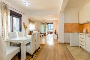 a kitchen and dining room with a white table and chairs at Sea View Apartments Perovic in Budva