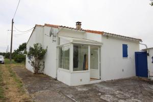 a white house with a large glass door at Maison 3 pièces Oléron 6 couchages SAINT GEORGES D'OLERON SGO000-434 in Saint-Georges-dʼOléron