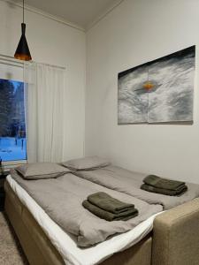 a bedroom with a bed with two towels on it at Kontion keidas Maaseudulla Varattavissa myös Takkatupa ja Sauna in Oulu