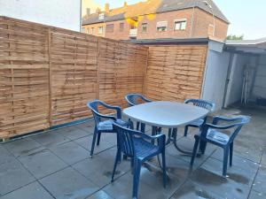 a table and chairs on a patio with a fence at Gäste Unterkunft 2 in Mönchengladbach