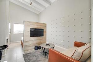 Una sala de estar con un sofá, un televisor y una mesa. en The Paddocks Dainfern, en Fourways
