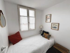 Un dormitorio pequeño con una cama y una ventana. en Appartement Liseron, en Saint-Martin-de-Ré
