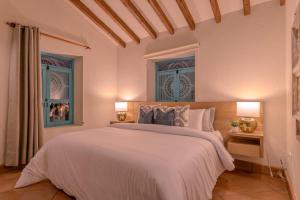 a bedroom with a large bed and two windows at Vista Bonita - Hacienda Guatape in Guatapé +66 photos