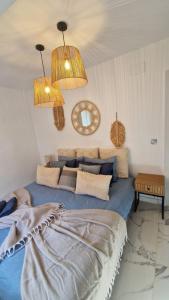 ein Schlafzimmer mit einem blauen Bett und zwei Lichtern in der Unterkunft White Apartment Calpe in Calpe + 14 Fotos