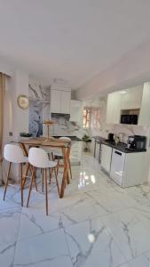 eine Küche mit einem Holztisch und weißen Schränken in der Unterkunft White Apartment Calpe in Calpe