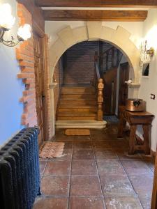 a hallway with a staircase and a brick wall at Apartamentos Villa Julieta in Ruente