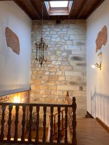 a staircase with a stone wall and a chandelier at Apartamentos Villa Julieta in Ruente