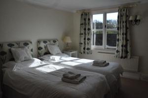 - une chambre avec 2 lits et des serviettes dans l'établissement Little Tidebrook Farm, à Wadhurst