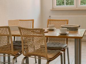 einen Tisch und Stühle mit Tassen und Schüsseln darauf in der Unterkunft "Unnen" in der Alten Schule Greetsiel in Krummhörn