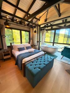 una camera da letto con un letto e una vasca in una stanza di Cabana Harmony | Jacuzzi I Vista pro Lago a Alfredo Wagner
