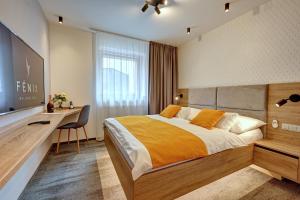 利贝雷茨Wellness Hotel Fénix的一间卧室配有一张床、一张书桌和一台电视