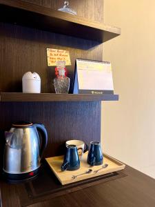 a shelf with two tea pots on a tray at The Studio Apartment at Selesa Hillhomes Bukit Tinggi Bentong in Bentong +14 photos