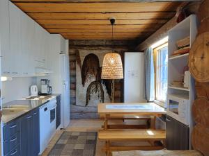 cocina con techo de madera y mesa en Kuusanka, en Syöte