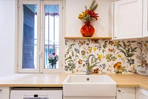 a kitchen with a sink and a vase with flowers on the wall at MAISON VIEUX CHÂTEAU - Vue Mer imprenable - Menton Vieille Ville in Menton +24 photos