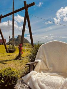 a blanket sitting on a bench in a field at Cabana Jardim Encantado in Barracão