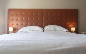 a large bed with a large headboard and two pillows at Heacham Manor Hotel in Hunstanton