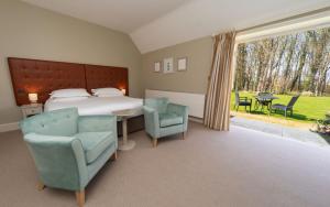 a bedroom with a bed and a table and chairs at Heacham Manor Hotel in Hunstanton +37 photos