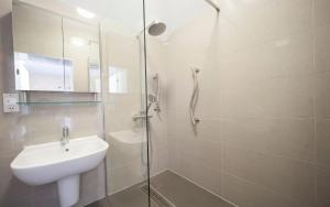 a bathroom with a sink and a glass shower at Heacham Manor Hotel in Hunstanton