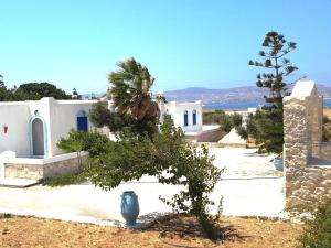 a white building with a tree in front of it at Wind Villas Pounda in Pounda